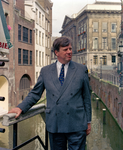 838970 Portret van mr. I.W. (Ivo) Opstelten op de Lichte Gaard te Utrecht, met op de achtergrond het Stadhuis.N.B. ...